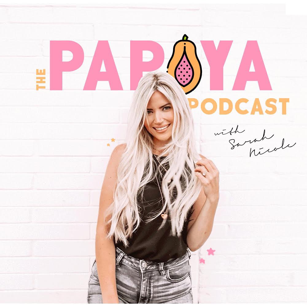 The Papaya Podcast with Sarah Nicole. Sarah is standing against a white brick wall.